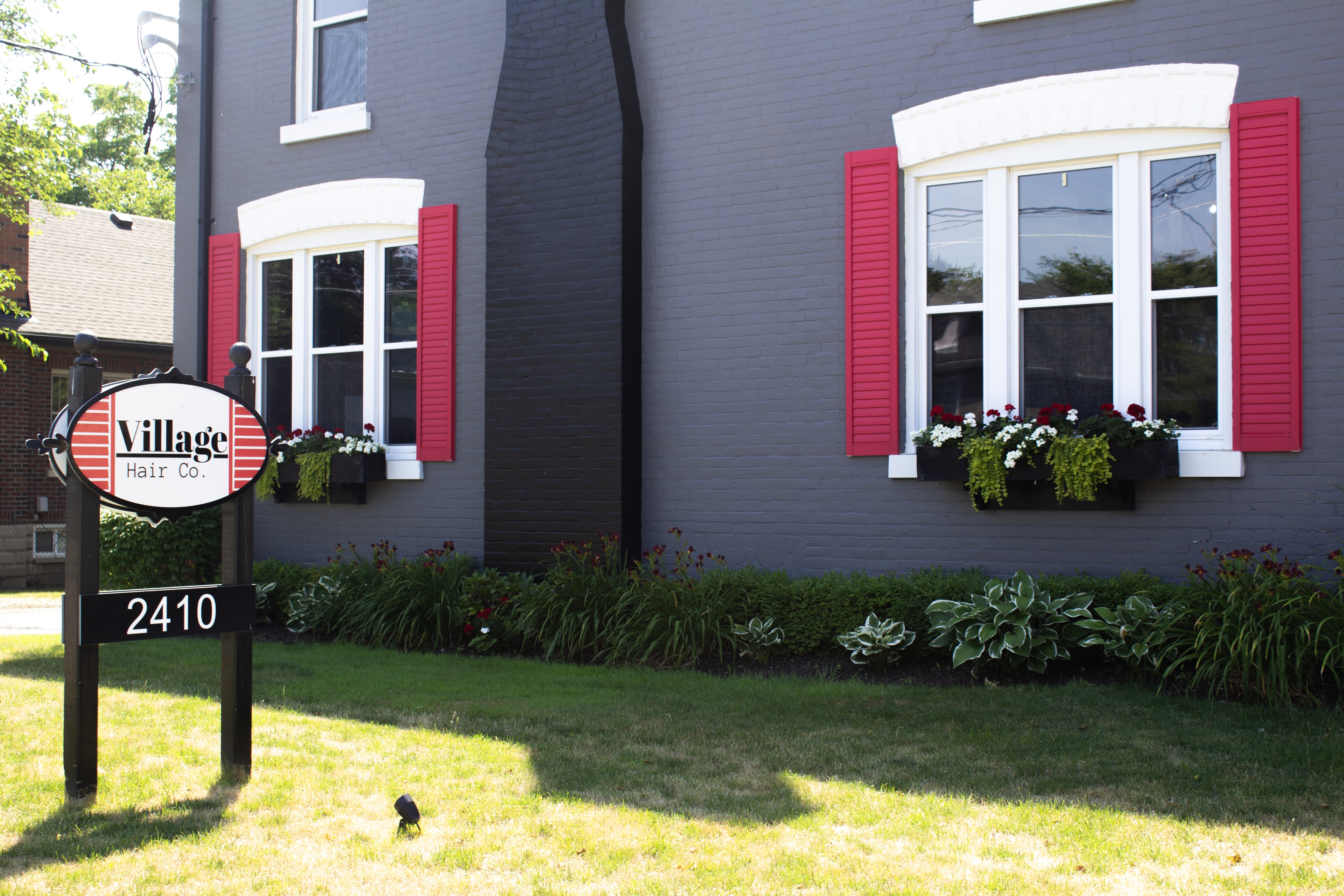 A stylist warmly welcoming a new client at Village Hair Co.